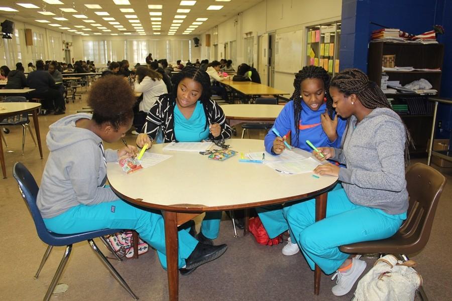 HOMEWORK HELP: (L- R) Mildred Augustin, Ruchama LaFontant, Carnelie Guillaume, and Taylor Douglas help each other with their homework after eating lunch. 
