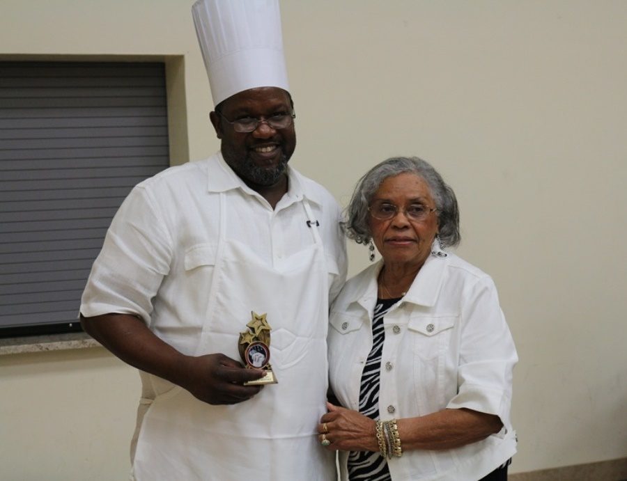 1ST PLACE CUISINE: The Rev. Michael Wilson, father of the Hurricanes own Digital Design Instructor Anthony Bell, accepts the winning trophy for his winter squash dish from President Arneatha Roberts as The greater Palm Beaches Business and Professional Women’s Club, Inc. featured a dozen of “The Best Cooks in Palm Beach County” at their 20th Annual Men’s Cookery event. The coconut cake, ham and macaroni and cheese were particular hits as other chefs won awards for their tasty dishes Feb. 25 at the Salvation Army in West Palm Beach.