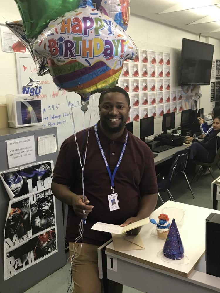 HOW OLD ARE YOU NOW? Digital Design teacher Anthony Bell gets ready to blow out his candles as students shower him with birthday gifts. 