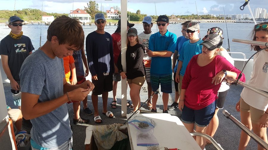 GET THE HOOK: The Marine Technology Academy students showed what fishing is all about. Before they set off to start the day, they watched how to put certain types of bait on their hook.