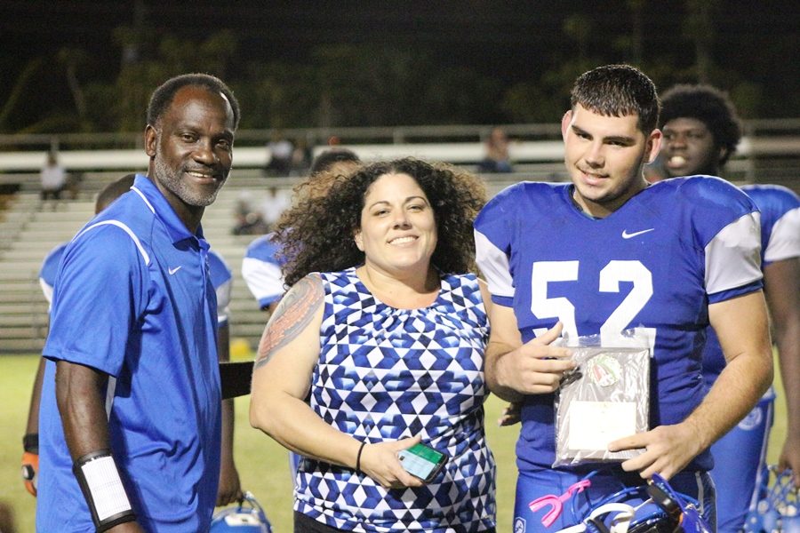 A NIGHT TO REMEMBER: Collin Keller poses with his mother and Coach Timpson on a night when the varisity football players were acknowledged. The Canes had lost the game however,  56-0. 