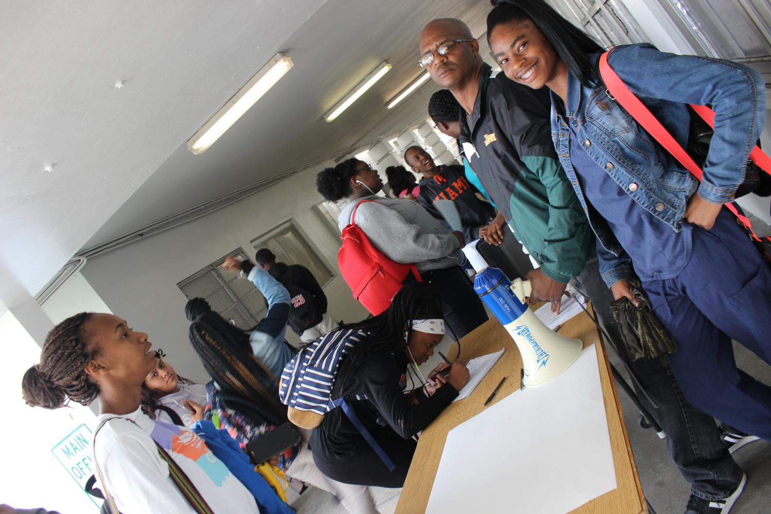 FLAG FOOTBALL: Students Toni Andrews, Nia Filsaime, and Brenay Porter sign up for flag football. While sophomore , track-runner , Teliyah Greathouse posed with Coach Kelly.