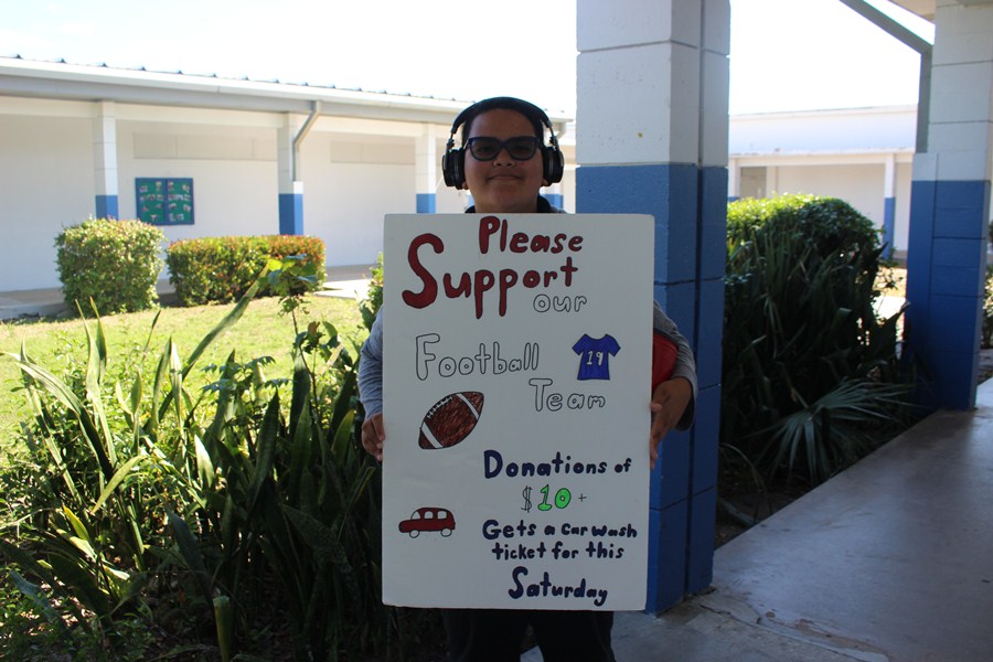 SUPPORT WANTED:
Alyssa Tenorio, a fellow Cane stands with poster in support of the Inlet Grove football team.