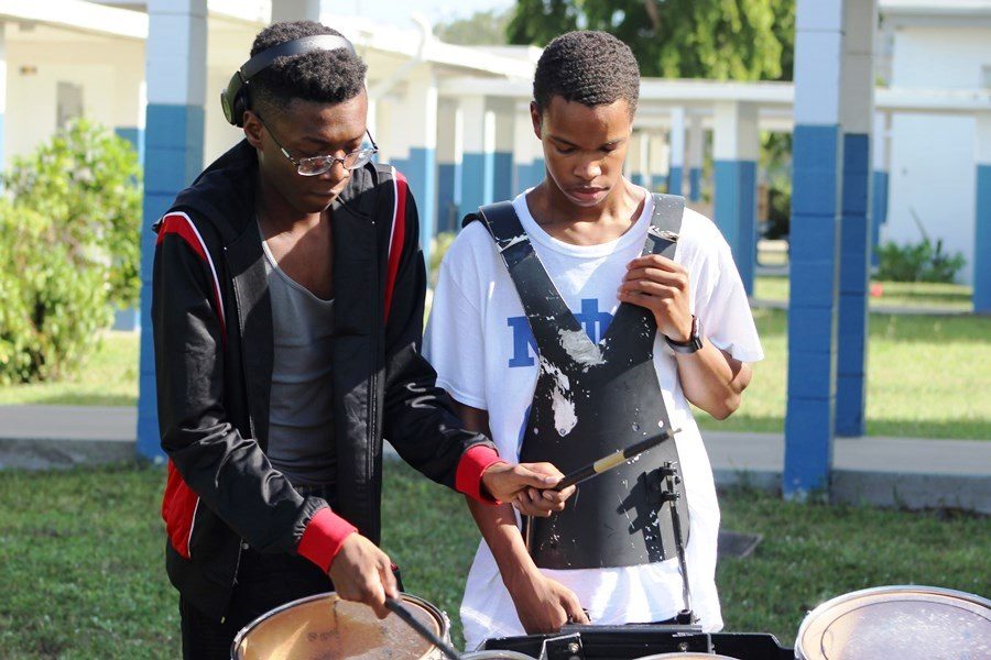TO THE BEAT OF HIS OWN DRUM: Jouberson Joseph (Left) teaches Collin Lovelace a new cadence for their next parade.