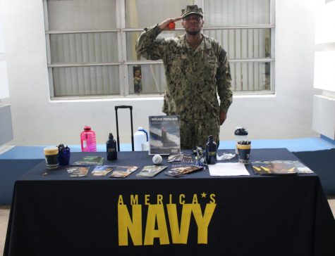 BRIDGING THE GAP: Operation Specialist William Wise enlightens student Jalen Giles on the possibilities and oppurtunities available afforded by the U.S Navy through brochures and  pamphlets while showcasing U.S Navy souvenirs.