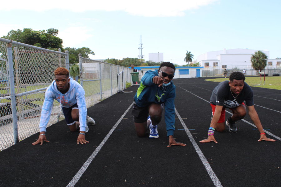 SWIFT CANES: Coach Donovans 2nd period class participates in a eight lap run. Carl Thelusma, in the middle, said, the purpose of this exercise is to focus on your legs and maintain endurance.” Donvarious Johnson, right, said, its a cardio workout to build the muscles in your legs. Jaderius Peoples, left, said, it helps better my speed, stamina, and endurance.