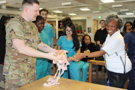MEDICAL MADNESS: Armed Forces came to speak with Medical Academy students about the different programs they have and the benefits of joining. Sergeant Ferguson is demonstrating what intestines feel like.