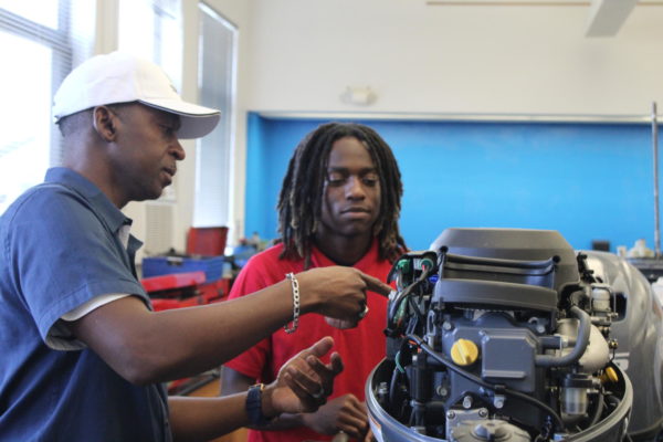 WATCH AND LEARN: The new marine technology teacher, Mr. Burt, demonstrates a motor to a Senior cane.