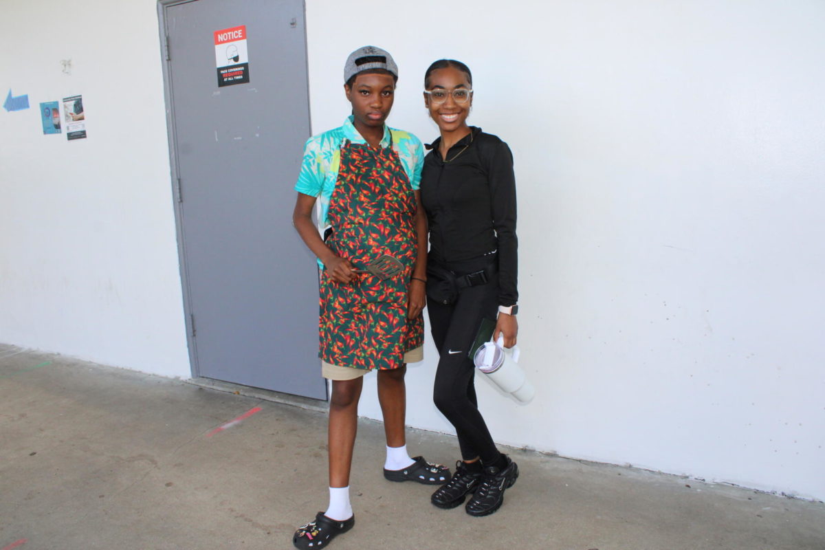 OUTDOORS:  For Wednesdays spirit week theme students dressed in athletic mom attire to impersonate  soccer moms, and others dressed in shorts, dress shirts, and aprons, and brought the accessories of tongs to impersonate barbecue dads. Photographed above are Dremaya Delva (left) and Brianna Blanc ( right)