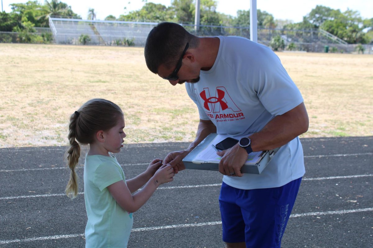 KID TAKE OVER: Coach Fritz brought his 5 year old daughter, Elise Fritz, for Bring Your Child to Work Day and watched as she showed him the new cut she had made while running the 5K with his students.