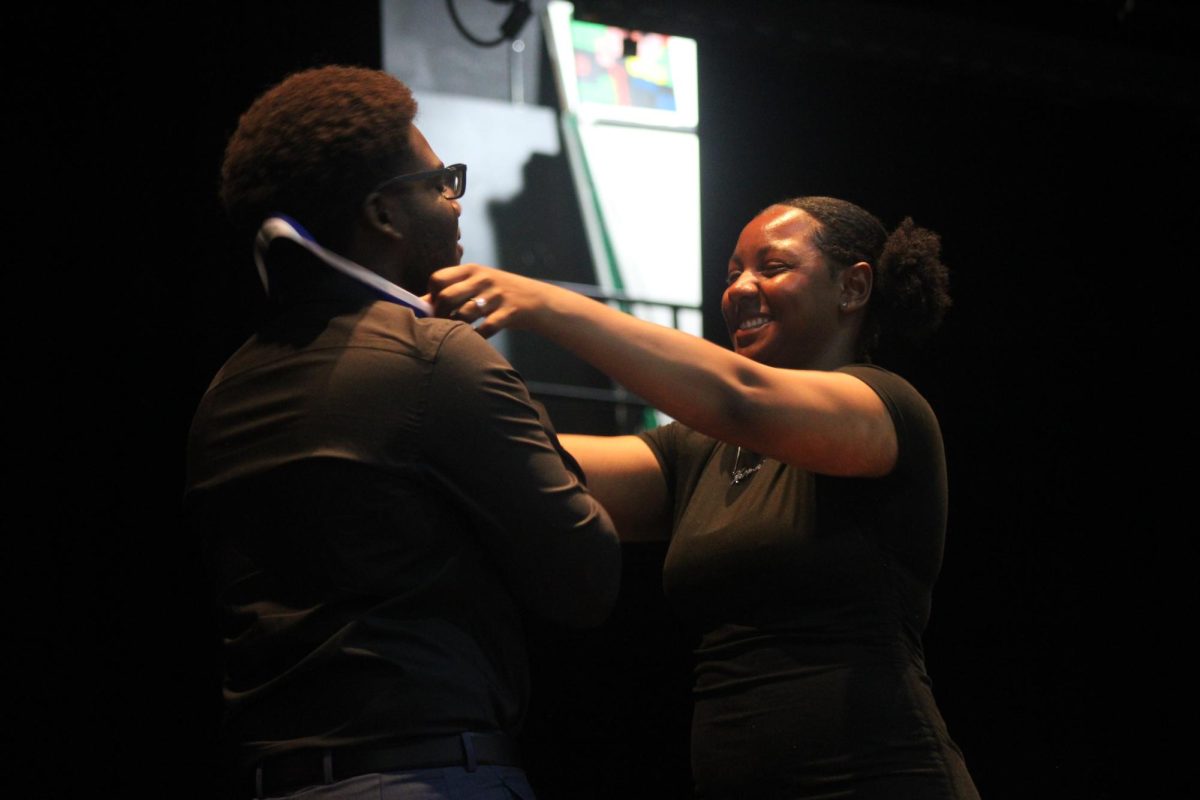 STAR OF THE NIGHT: Historian Karma McLeod (Right) honors Danjel Saint-Fleur with a Medal for graduating with his Associate of Arts (AA) degree from Palm Beach State College, at Senior Awards Night, held in the auditorium. 