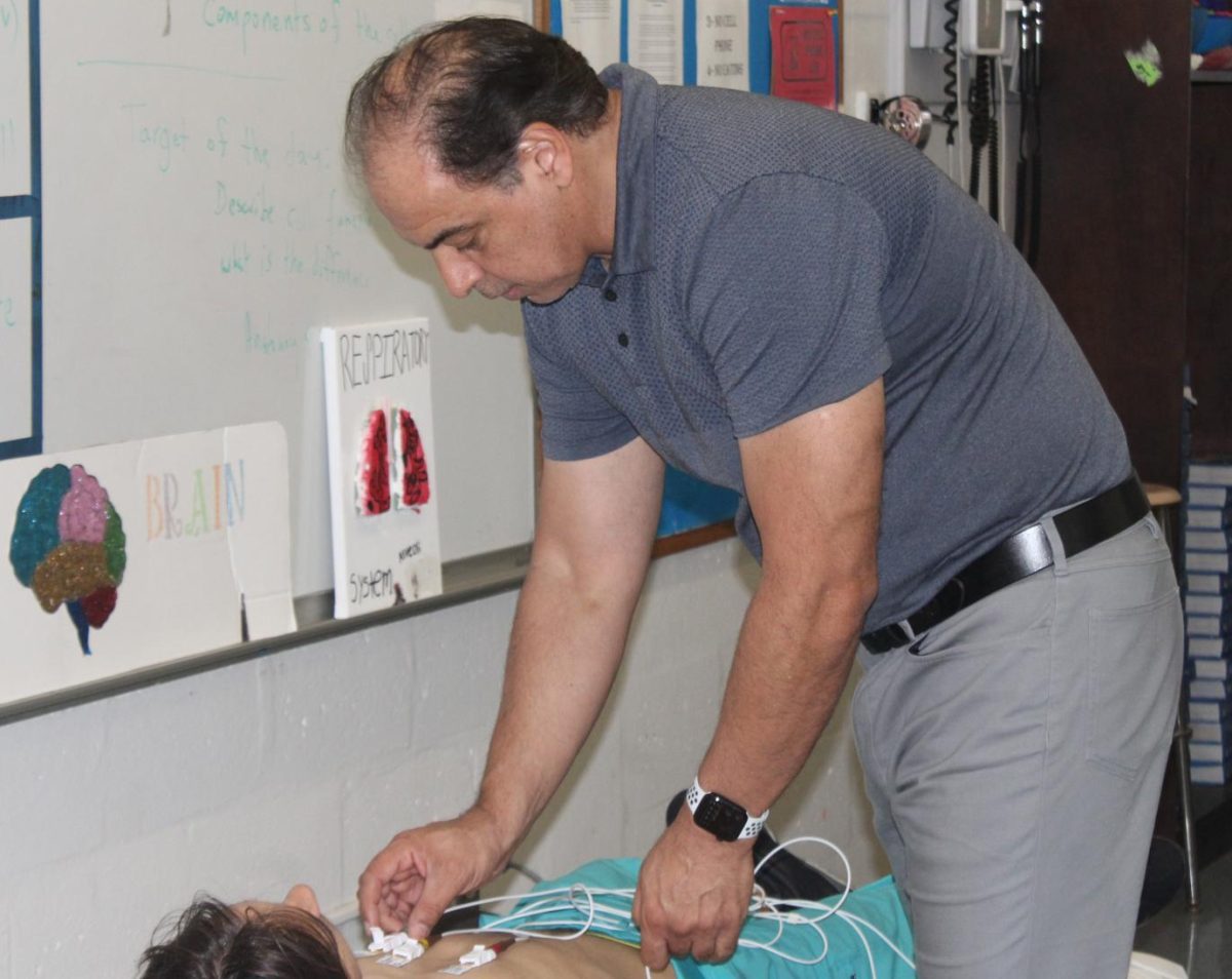 FOLLOW THE RHYTHM: Medical teacher Dr. Ghasemi teaches his EKG students about how to measure a heart rate on an EKG machine during 4th hour.