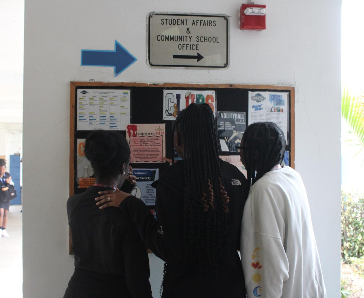 SETTLING IN: As the new school year begins, many students start looking for clubs to join. During lunch, a group of friends check out the club flyers posted in front of the cafeteria.