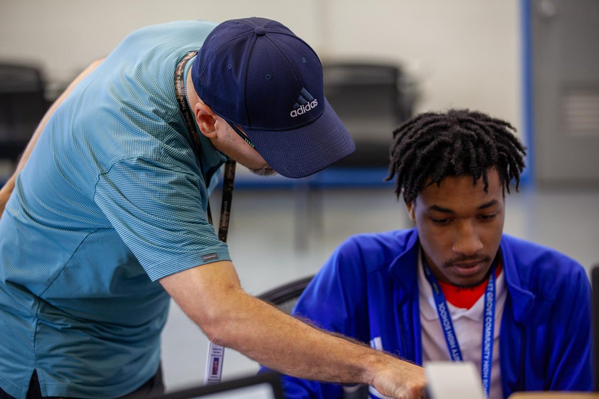 WORK IN PROGRESS: Mr. Martinez, the web design instructor, is helping Terry Louisdor, a junior web design student, work on an app for the school that involves a scanner to scan IDs to check in and out of bathrooms.