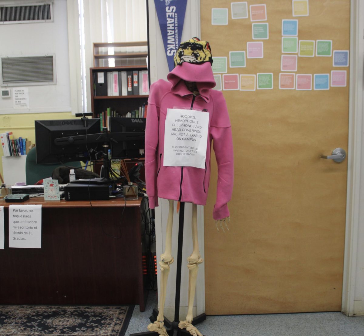 ENFORCEMENTS: A pink hoodie and beanie were put on view, serving as a visual reminder of the dress code policy.