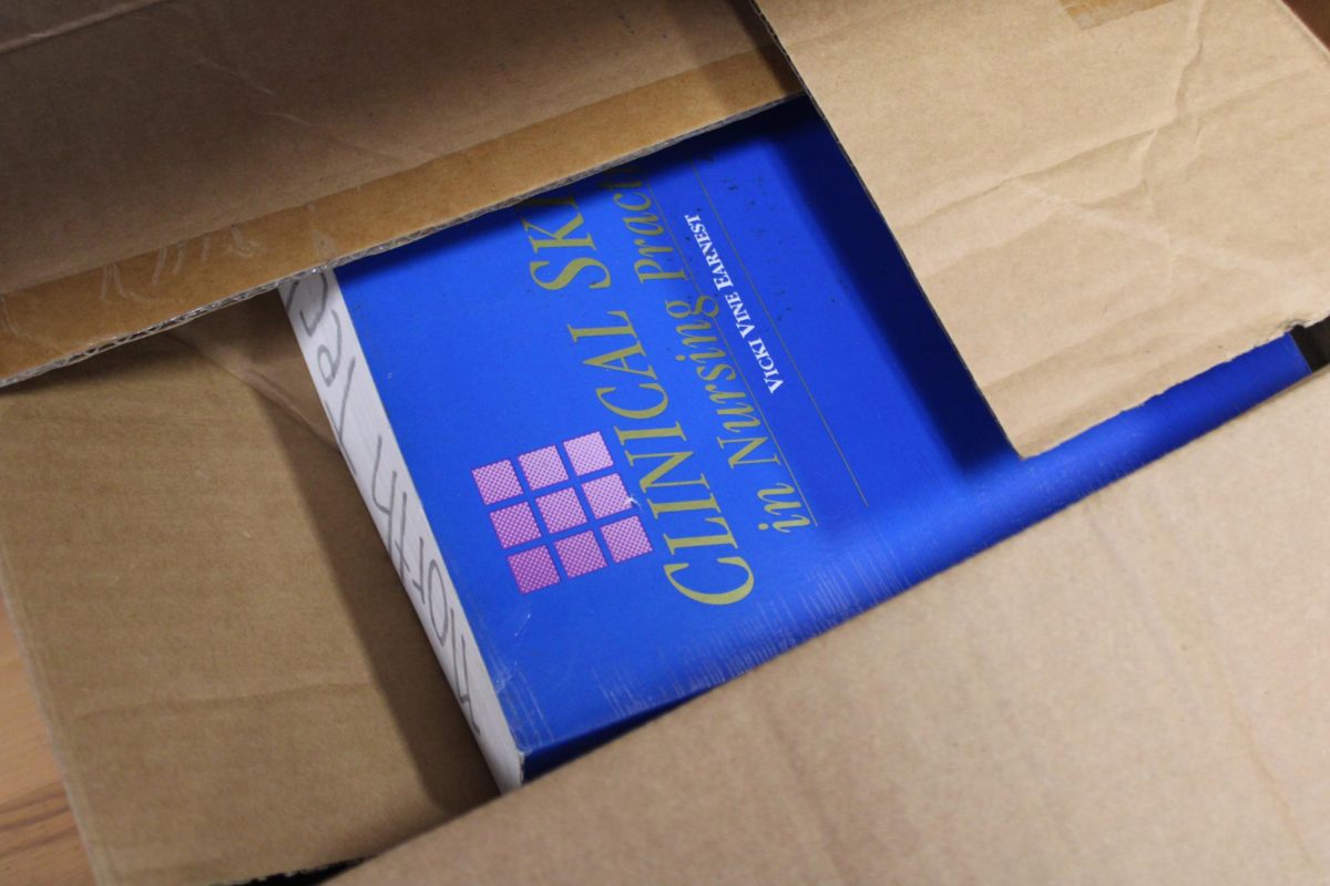 NEW ARRIVAL: A nursing textbook titled Clinical Skills and Nursing Practice sits inside an open box.