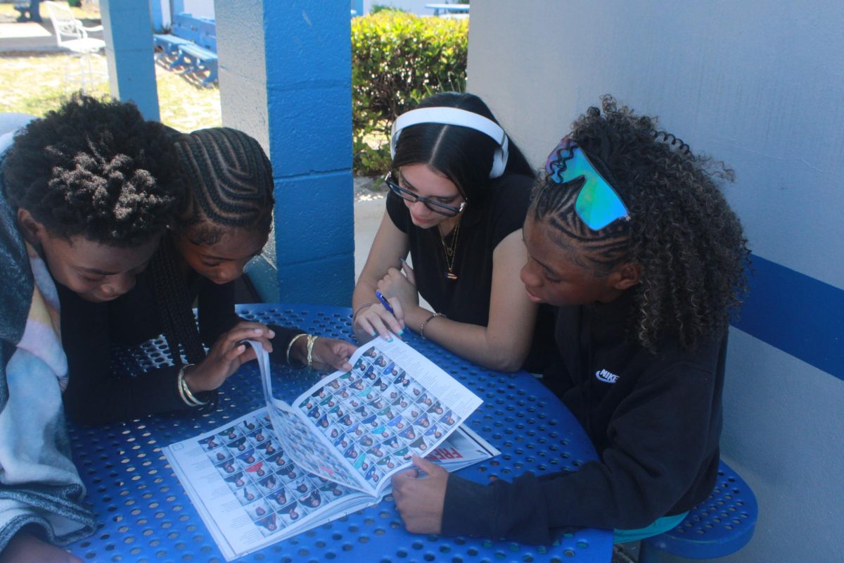 CURIOSITY: Students taking a glance at this year's yearbook "Different By Design." (Settings: Shutter Speed 1/250, Aperture f/10, and ISO 800.)